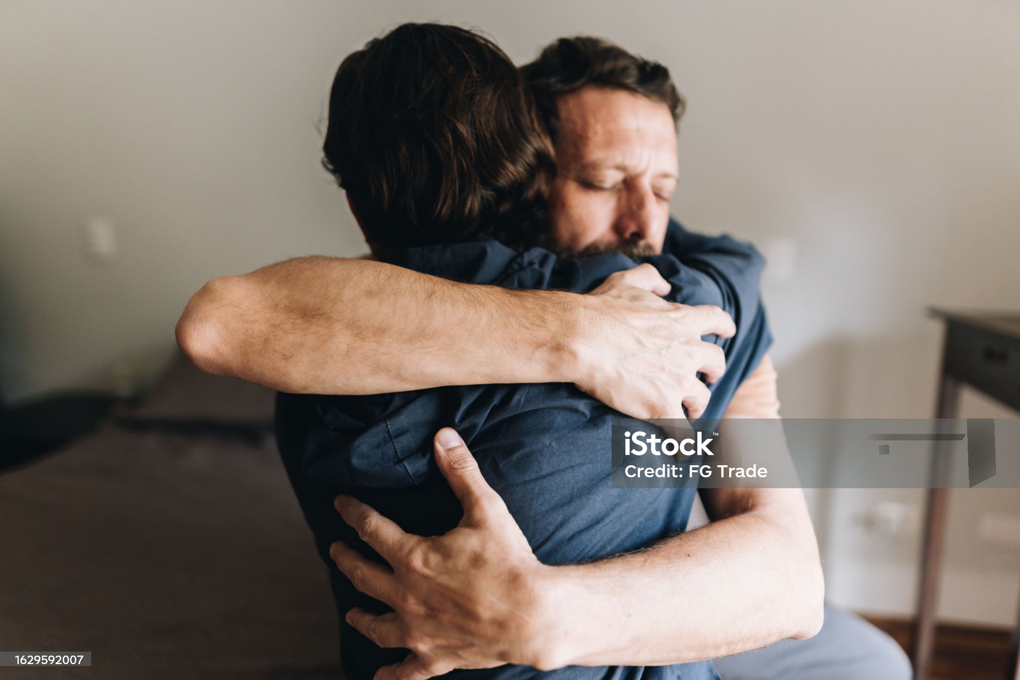 Father and son embracing at home